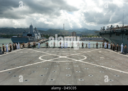 Matrosen und Marinesoldaten Mann die Schienen an Bord USS Pearl Harbor. Stockfoto