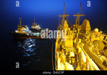 Schlepper ziehen USS Pioneer aus der Military Sealift Command gechartert M/V Tern, ein Schwimmer-Float-ein-/Transportschiff. Stockfoto