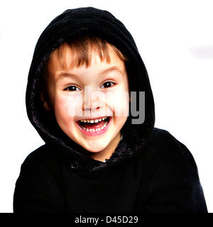 Fünf Jahre alten Jungen in einem schwarzen Hoodie Sweatshirt mit fahler Haut, braunes Haar und braune Augen vor einem weißen Hintergrund, die Lächeln ist Stockfoto