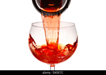 Nahaufnahme von einem Weinglas mit Rotwein aus einer Karaffe gießen. Stockfoto