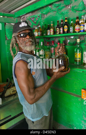 Murphy, der Besitzer Rootsmans Bar mit seinem Busch Rum, Carrs Bay, Montserrat Stockfoto