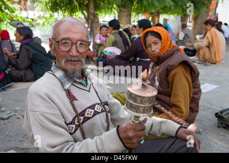 Ältere männliche Pilger tragen eine Gebetsmühle, in einer Gruppe von Pilgern auf einem Festival in Soma Gompa, Leh (Ladakh) Jammu & Kaschmir, Indien Stockfoto