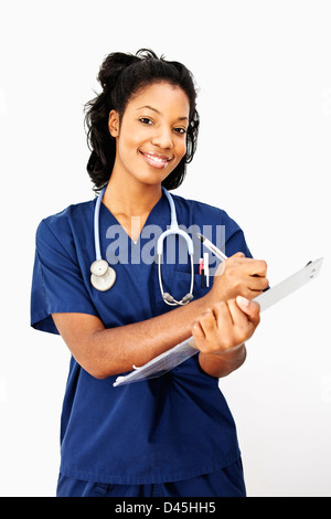 Eine lächelnde junge Krankenschwester Notizen Stockfoto