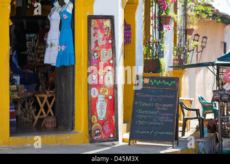 Eine alltägliche Straßenszene in der kolonialen Stadt Suchitoto in El Salvador. Ein Shop und ein Café mit einer Tafel Menü außerhalb Stockfoto
