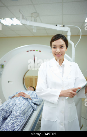 ein Arzt vor einem Patienten auf CT-Scannerbett liegend Stockfoto