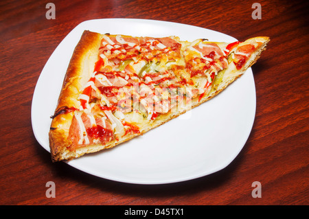 Stück Pizza isoliert auf weißem Teller abgeschnitten Stockfoto