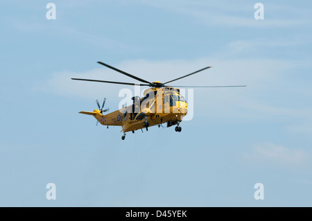 Eine gelbe RAF Sea King-Rettung Hubschrauber schwebt gezeigt. Stockfoto