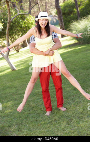 Junge Paare, die Spaß zusammen im Garten Stockfoto
