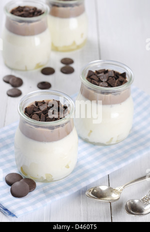 Fruchtdessert mit Ananas und Schokolade in Gläsern über weißem Holz Hintergrund Stockfoto