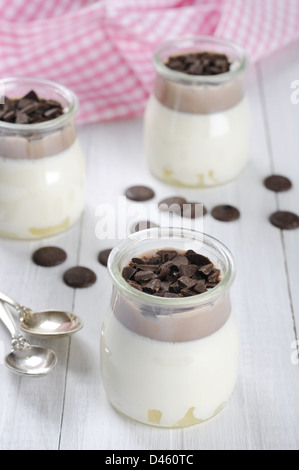 Fruchtdessert mit Ananas und Schokolade in Gläsern über weißem Holz Hintergrund Stockfoto