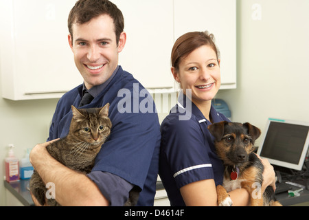 Männliche Tierarzt und Krankenschwester Holding Katze und Hund In der Chirurgie Stockfoto