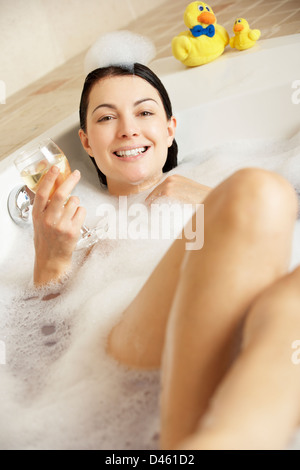 Frau mit Glas Wein gefüllt Schaumbad entspannen Stockfoto