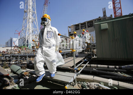 Fukushima, Japan. 6. März 2013. Mitglieder der Medien tragen Schutzanzüge und Masken werden von TEPCO-Mitarbeiter zu Fuß in Richtung in Common Pool Building für abgebrannte Brennelemente Pool begleitet wo die Brennstäbe für den Rückbau, gespeichert wird, wie sie im Tokyo Electric Power Co. (TEPCO) des Tsunami verkrüppelt Fukushima Daiichi Atomkraftwerk in Fukushima Prefectureahead des zweiten Jahres Jubiläum der 11. März besuchen , 2011 Tsunami und Erdbeben. Bildnachweis: ZUMA Press, Inc. / Alamy Live News Stockfoto