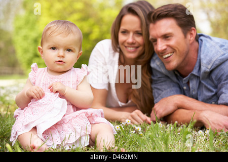 Eltern mit Babymädchen sitzt im Bereich der Sommerblumen Stockfoto