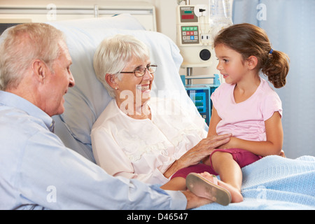 Enkelin besucht Großmutter im Krankenhausbett Stockfoto