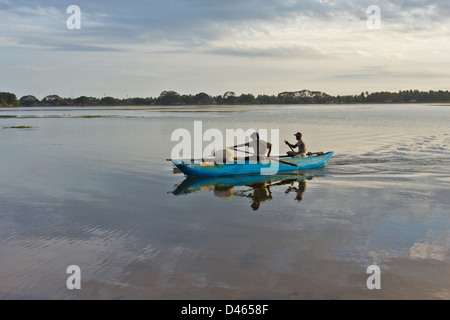 FISCHER MIT IHREM FANG ZURÜCKKEHREN, AUS DEM SEE IN TISSAMAHARAMA BEI SONNENUNTERGANG Stockfoto