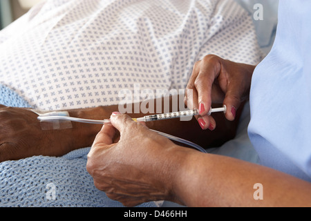 Krankenschwester Injektion Senior männlichen Patienten im Krankenhausbett Stockfoto