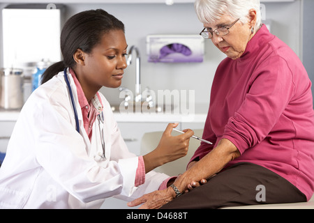 Arzt geben Senior weiblichen Patienten Injektion Stockfoto