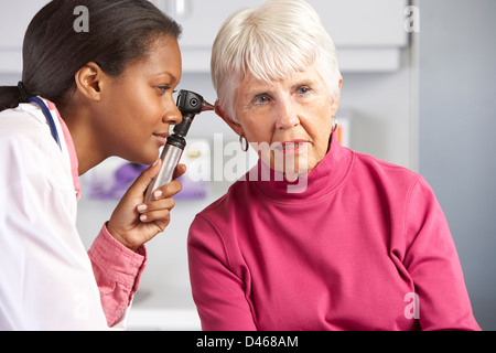 Arzt untersuchen Senior weiblichen Ohren des Patienten Stockfoto