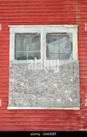 Vernagelten Fenster in verlassenen Gebäude mit roten Schindeln Stockfoto