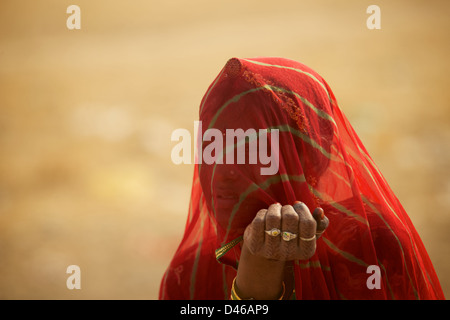 Eine junge Indianerin am Stadtrand von Bikaner in Nordindien Rajasthan. schirmt ihr Gesicht vom Wüstenwind und heißen Sonne Stockfoto
