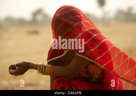 Eine junge Indianerin am Stadtrand von Bikaner in Nordindien Rajasthan. schirmt ihr Gesicht vom Wüstenwind und heißen Sonne Stockfoto