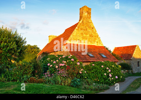 Traditionelles Haus in Stein mit Blumen in der Bretagne, Frankreich Stockfoto