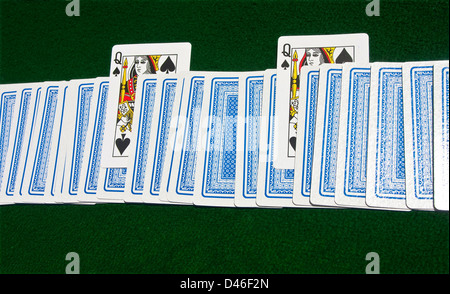 Kartenstapel verdeckt auf dem Tisch mit zwei Queens of Spades bei grün. Stockfoto