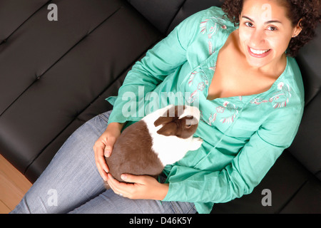 Eine junge, brasilianische Frau mit einem Kaninchen. Stockfoto