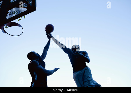 Zwei junge schwarze Männer Basketball zu spielen, nach der Arbeit. Stockfoto