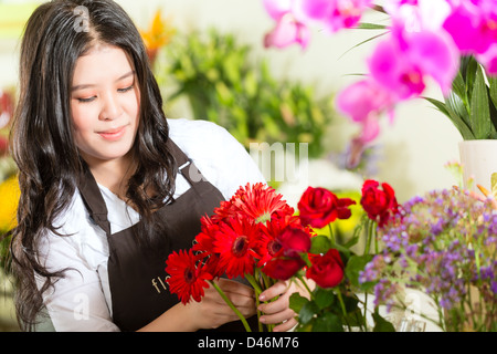 Freundliche asiatische Floristin oder Verkäuferin in einem Blumenladen Stockfoto