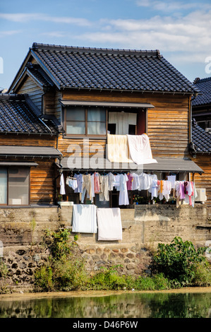 Waschtag in Japan: hängen die Wäsche aus den Fenstern von einem traditionellen japanischen Holzhaus am Fluss Stockfoto