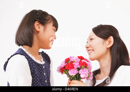 Tochter mit Blumengeschenk für Mutter Stockfoto
