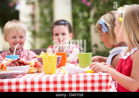Gruppe von Kindern genießen Tee-Party im freien Stockfoto