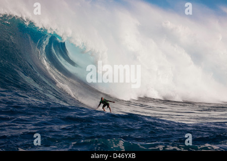 Eine Schlepp-Surfer fällt hinunter das Gesicht Hawaiis big Surf am Peahi (Backen) aus Maui, Hawaii, USA. Stockfoto