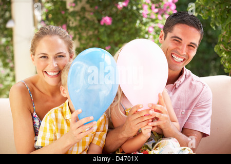 Familie auf Sofa zusammen mit Luftballons Stockfoto