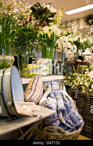 Schönes Interieur Bild der Raum voller Nachahmung Blumen, Zuckerrohr Kissen Korb und alte Zinn, den Eimer in den Vordergrund gestellt werden Stockfoto