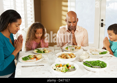 Familie sagen Gnade vor der Mahlzeit zu Hause Stockfoto