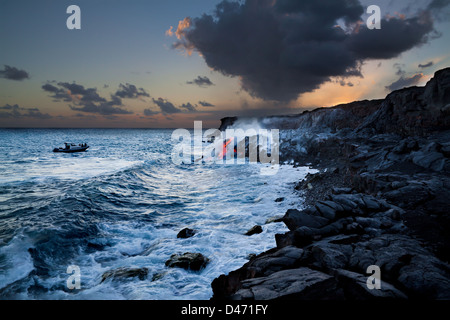 Ein Boot bekommt einen genauen Blick auf Pahoehoe-Lava fließt von Kilauea, die den Pazifischen Ozean in der Nähe von Kalapana, Hawaii erreicht hat. Stockfoto