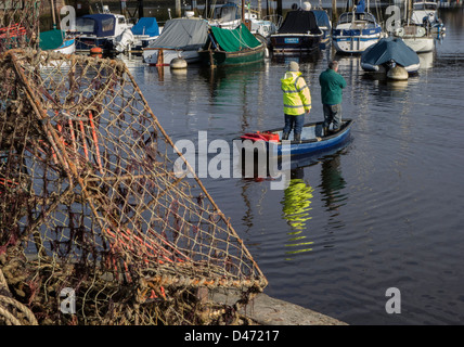 Lymington Hafen, zwei Männer in einem kleinen Boot, Hampshire, England, UK. Europa Stockfoto