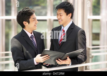 Zwei Geschäftsleute diskutieren Dokument außerhalb Büro Stockfoto