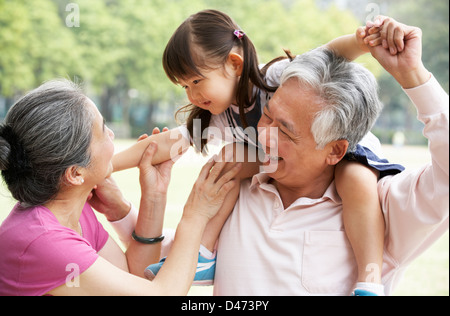 Chinesische Großeltern geben Enkelin Fahrt auf Schultern Stockfoto