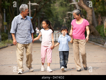 Chinesische Großeltern zu Fuß durch den Park mit Enkeln Stockfoto