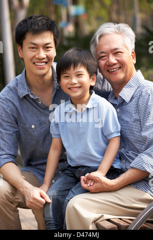 Männlichen Multi Genenration chinesische Familie Gruppe zusammensitzen auf Bank im Park Stockfoto