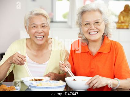 Zwei hochrangige chinesische Frauen sitzen zu Hause Essen Mahlzeit Stockfoto