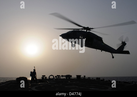 Segler bereiten ein Gepäcknetz mit leeren Holzpaletten zu einem MH-60 s Sea Hawk Hubschrauber befestigen Stockfoto