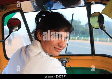 Rikscha-Fahrer Sunita Chaudhry sitzt in ihrem Fahrzeug und einem Lächeln auf einer Straße in Neu-Delhi, Indien, 18. Februar 2013. Chaudhry ist seit den letzten acht Jahren einen Rikscha-Taxi-Service in Neu-Delhi tätig. Internationaler Frauentag wird am 8. März 2013 gefeiert. Foto: Doreen Fiedler Stockfoto