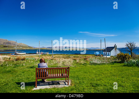 Frau sitzt auf einer Sitzbank Kilchoan, Ardnamurchan, Highlands, Schottland, Vereinigtes Königreich Stockfoto