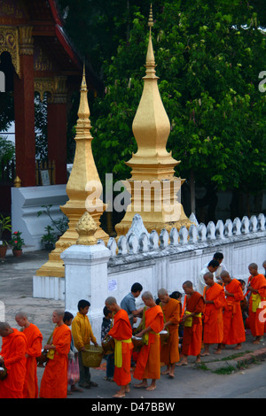 Mönche, die Verarbeitung in der Morgendämmerung um Almosen von Reis in Luang Prabang, Laos, Indochina, Südostasien, Asien Stockfoto