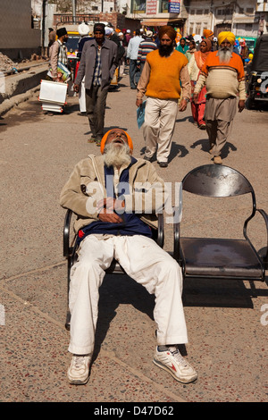 Ein Punjabi Mann schlief auf einen öffentlichen Platz in Amritsar mit bunten Massenszene Stockfoto